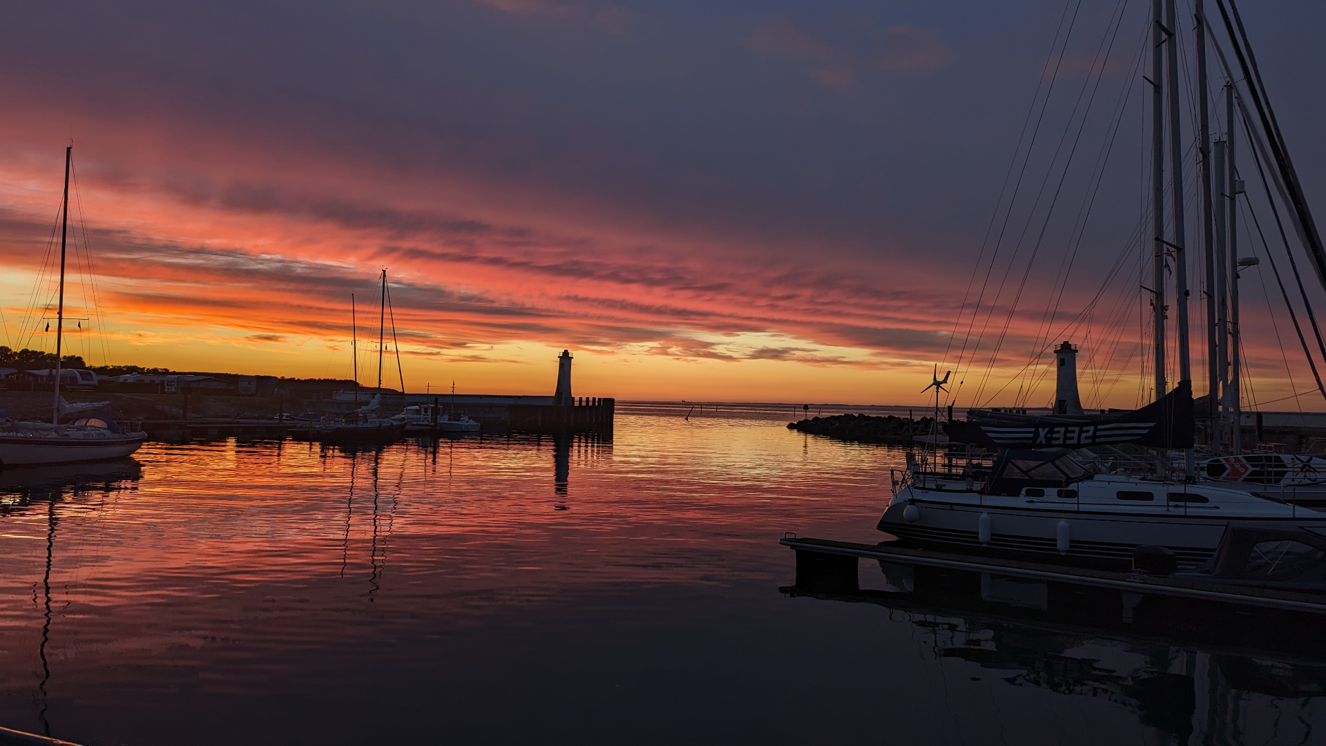 Haven bij zonsondergang met silhouetten van masten
